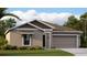 Charming single-story home with a well-manicured lawn and a neutral-toned facade at 263 Puma Loop, Groveland, FL 34736