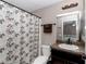Bathroom with dark wood vanity and shower with decorative curtain at 4111 Se 131St Ln, Belleview, FL 34420