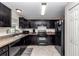 This kitchen features dark cabinetry, tile floors, and essential appliances for convenient meal preparation at 4111 Se 131St Ln, Belleview, FL 34420