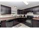 An updated kitchen featuring sleek, dark cabinets, neutral countertops, and modern appliances at 4111 Se 131St Ln, Belleview, FL 34420