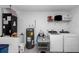Functional laundry room with washer, dryer, and storage shelves at 4111 Se 131St Ln, Belleview, FL 34420