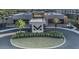 Modern community entrance featuring sleek architecture, lush landscaping, and a welcoming circular drive at 7540 Brooklyn Dr, Kissimmee, FL 34747
