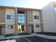 A view of the townhouse's exterior showing the building's architectural style and a parking area at 7540 Brooklyn Dr, Kissimmee, FL 34747