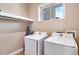 Bright laundry room featuring modern appliances, storage shelf, and tiled floors at 7540 Brooklyn Dr, Kissimmee, FL 34747