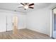 Bright bedroom featuring wood floors, a ceiling fan, and access to a balcony and bathroom at 113 Grand Reserve Ct, Davenport, FL 33837
