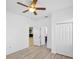 A bright bedroom featuring wood floors, a ceiling fan, a closet, and doorway to the kitchen and bath at 113 Grand Reserve Ct, Davenport, FL 33837