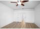Bedroom with wood floors featuring a ceiling fan and door leading to a bathroom and kitchen at 113 Grand Reserve Ct, Davenport, FL 33837