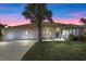 Charming single-story home featuring a lush front yard, a three car garage, and a welcoming blue front door at 113 Grand Reserve Ct, Davenport, FL 33837