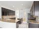 Modern kitchen with dark cabinetry, granite countertops, stainless steel appliances, and center island for food prep and dining at 113 Grand Reserve Ct, Davenport, FL 33837