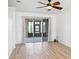 Bright living area featuring wood floors, sliding glass doors to an outdoor patio, and modern ceiling fan at 113 Grand Reserve Ct, Davenport, FL 33837