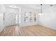 Bright living area with wood floors, large windows, and a minimalist aesthetic, illuminated by modern light fixture at 113 Grand Reserve Ct, Davenport, FL 33837