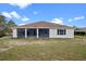 View of the home's rear exterior, highlighting its screened-in porch and surrounding backyard at 113 Grand Reserve Ct, Davenport, FL 33837