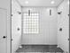 Modern, tiled shower with dual showerheads, glass block window and stone floor at 113 Grand Reserve Ct, Davenport, FL 33837