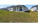 Expansive backyard featuring a covered patio, lush lawn, and views of neighboring homes at 1667 Ruby Ln, Lake Alfred, FL 33850