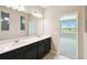 Modern bathroom featuring double sinks, quartz countertop, and a view of the adjacent bedroom at 1667 Ruby Ln, Lake Alfred, FL 33850