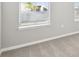 Bedroom showcasing plush carpeting, neutral paint and trim, and bright natural light from the window at 1667 Ruby Ln, Lake Alfred, FL 33850