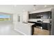Open concept kitchen with stainless appliances, tile floors and island with sink and quartz counters at 1667 Ruby Ln, Lake Alfred, FL 33850