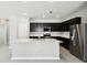 Modern kitchen featuring dark cabinetry, stainless steel appliances, and a central island with sink at 1667 Ruby Ln, Lake Alfred, FL 33850