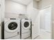 Well-equipped laundry room with modern washer and dryer set, and a nearby door for easy access at 1667 Ruby Ln, Lake Alfred, FL 33850
