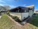 Exterior view of property with stucco walls and a brown roofline, situated on a grassy lot under a clear blue sky at 1880 N Crystal Lake Dr # 65, Lakeland, FL 33801