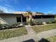 View of front entrance featuring a well-kept lawn, walkway, and a stylish neutral colored exterior with mature landscaping at 1880 N Crystal Lake Dr # 65, Lakeland, FL 33801