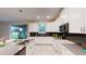 Modern kitchen with white cabinets, stainless steel appliances, and a breakfast bar overlooking backyard at 3217 Armstrong Ave, Clermont, FL 34714