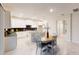 Bright, open kitchen with white cabinets, an island, and a dining area with wood table at 3217 Armstrong Ave, Clermont, FL 34714