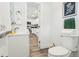 Modern bathroom features tiled shower and sink with view into kitchen at 515 9Th St, Winter Garden, FL 34787