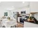 Beautifully designed open kitchen with stainless steel appliances, white cabinets, and a dining area at 515 9Th St, Winter Garden, FL 34787