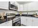 Modern kitchen with stainless steel appliances, black countertops, and white cabinets at 515 9Th St, Winter Garden, FL 34787