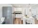Open-concept kitchen boasts stainless steel appliances, white cabinetry, and views into the bedroom at 515 9Th St, Winter Garden, FL 34787