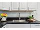 Close-up of kitchen with stainless steel sink, black countertop, and white cabinets at 515 9Th St, Winter Garden, FL 34787