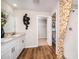 Modern bathroom features double vanity, decorative wall art, wood floors, and tiled shower with stylish curtain at 1010 Foreshore Ln, Haines City, FL 33844