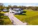 Areal view of a single-Gathering home featuring a classic white exterior, dark shutters, a welcoming porch, and a spacious lawn at 5118 Norriswood Dr, Mulberry, FL 33860