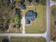 Areal view of a single-Gathering home featuring a classic white exterior, dark shutters, a welcoming porch, and a spacious lawn at 5118 Norriswood Dr, Mulberry, FL 33860