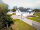 Attractive white home featuring a three-car garage and a detached matching garage, set on a lush lawn at 5118 Norriswood Dr, Mulberry, FL 33860