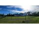 Charming white home with a gabled roof and a well-manicured lawn surrounded by a black chain-link fence at 5118 Norriswood Dr, Mulberry, FL 33860