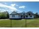 Inviting exterior featuring black fence, a front porch, and well-kept lawn at 5118 Norriswood Dr, Mulberry, FL 33860