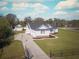 Aerial view of a charming white home with meticulous landscaping and a separate matching garage, adding value at 5118 Norriswood Dr, Mulberry, FL 33860