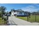 Long driveway leading to a home with a detached garage, well-maintained lawn, and a perimeter fence at 5118 Norriswood Dr, Mulberry, FL 33860