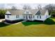 Inviting single-Gathering home featuring a classic white exterior, dark shutters, a welcoming porch, and lush green lawn at 5118 Norriswood Dr, Mulberry, FL 33860