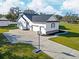 Beautiful white home with a black roof, three-car garage, and a basketball hoop in the driveway at 5118 Norriswood Dr, Mulberry, FL 33860