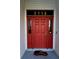 Close-up of a red front door with windows on either side and house number above the door at 5118 Norriswood Dr, Mulberry, FL 33860