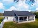 Rear exterior of home with a screened in patio and spacious yard at 5118 Norriswood Dr, Mulberry, FL 33860