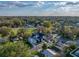 A bird's eye view reveals a modern home nestled amongst the trees with a manicured lawn and a neighboring community at 720 W 14Th St, Lakeland, FL 33805