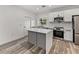 Stylish kitchen with stainless steel appliances, gray island, white countertops and cabinets, and wood-look flooring at 720 W 14Th St, Lakeland, FL 33805