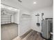 View into a garage with a peek into a utility room with wood-look flooring and shelving at 720 W 14Th St, Lakeland, FL 33805