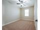 Cozy bedroom with neutral paint, plush carpet, a ceiling fan, and a bright window at 7729 Somersworth Dr, Kissimmee, FL 34747
