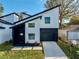 Modern two-story home with a black garage door, well-manicured lawn and geometric walkway at 720 W 14Th St, Lakeland, FL 33805
