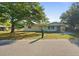 Charming single-story home with a well-maintained lawn and mature trees providing shade at 2453 Teri St, Auburndale, FL 33823